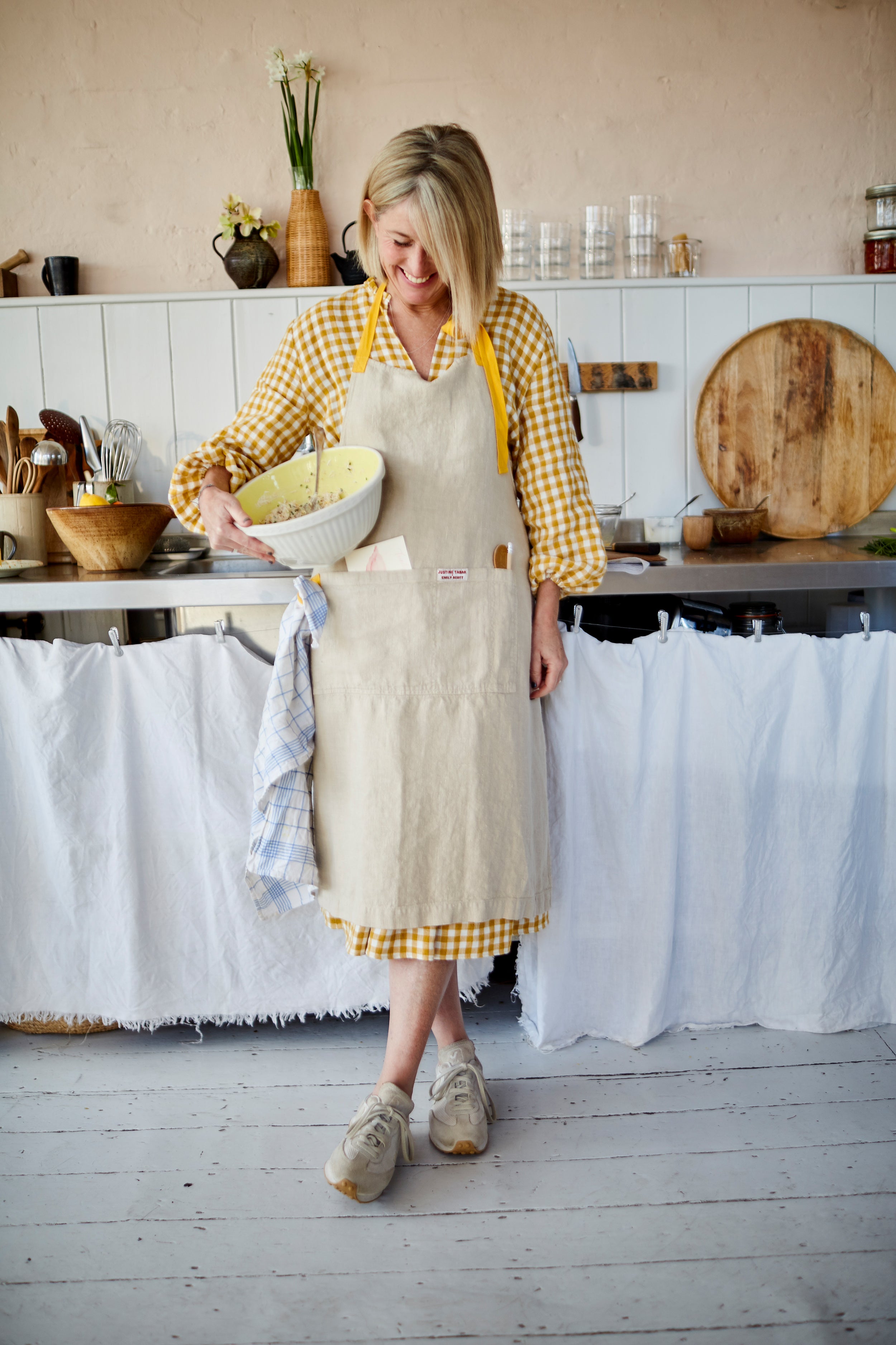 Natural linen apron with pocket and yellow straps.