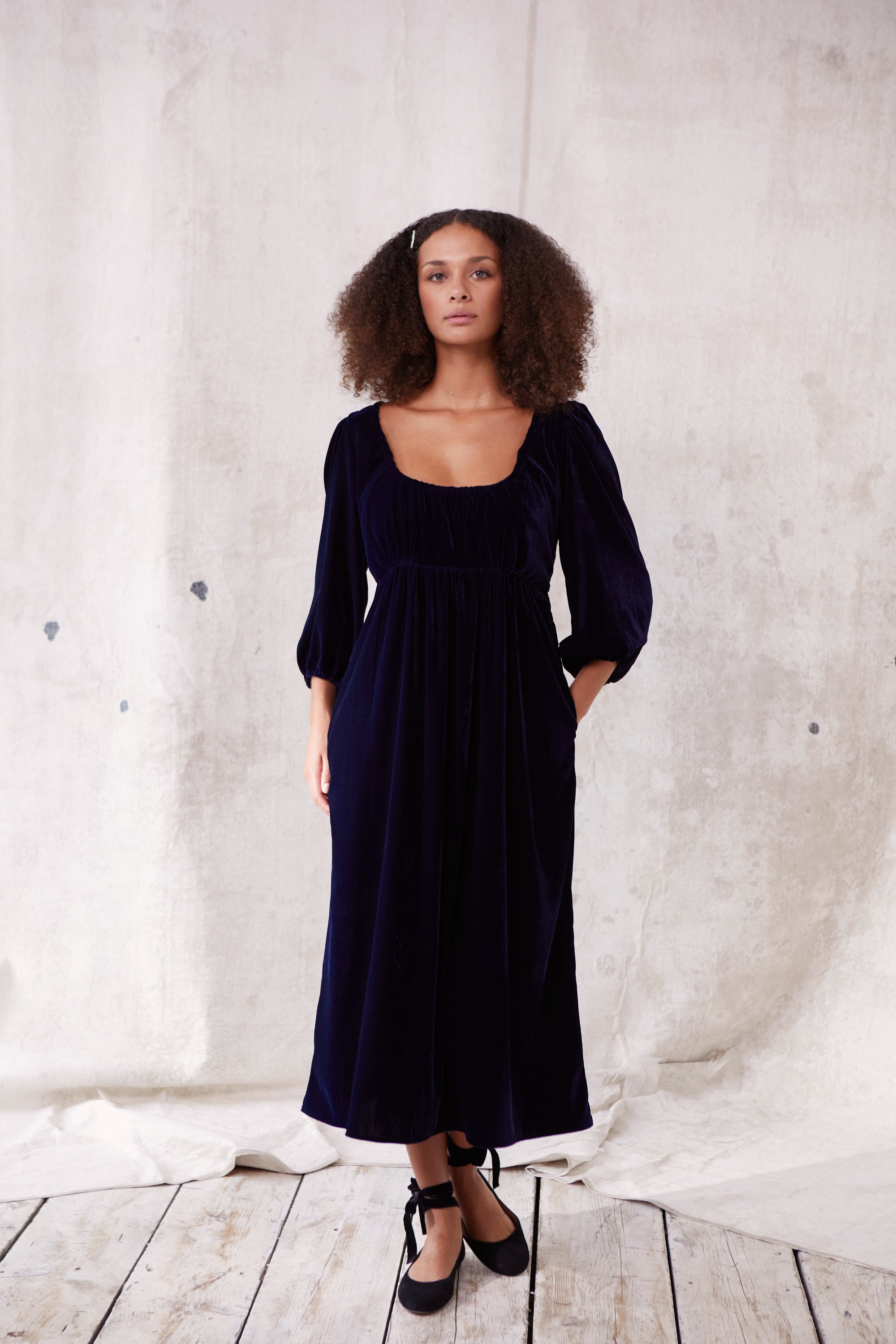 Sustainable blue velvet dress. Long sleeve, low round neck, empire line. Midi length. Made in England