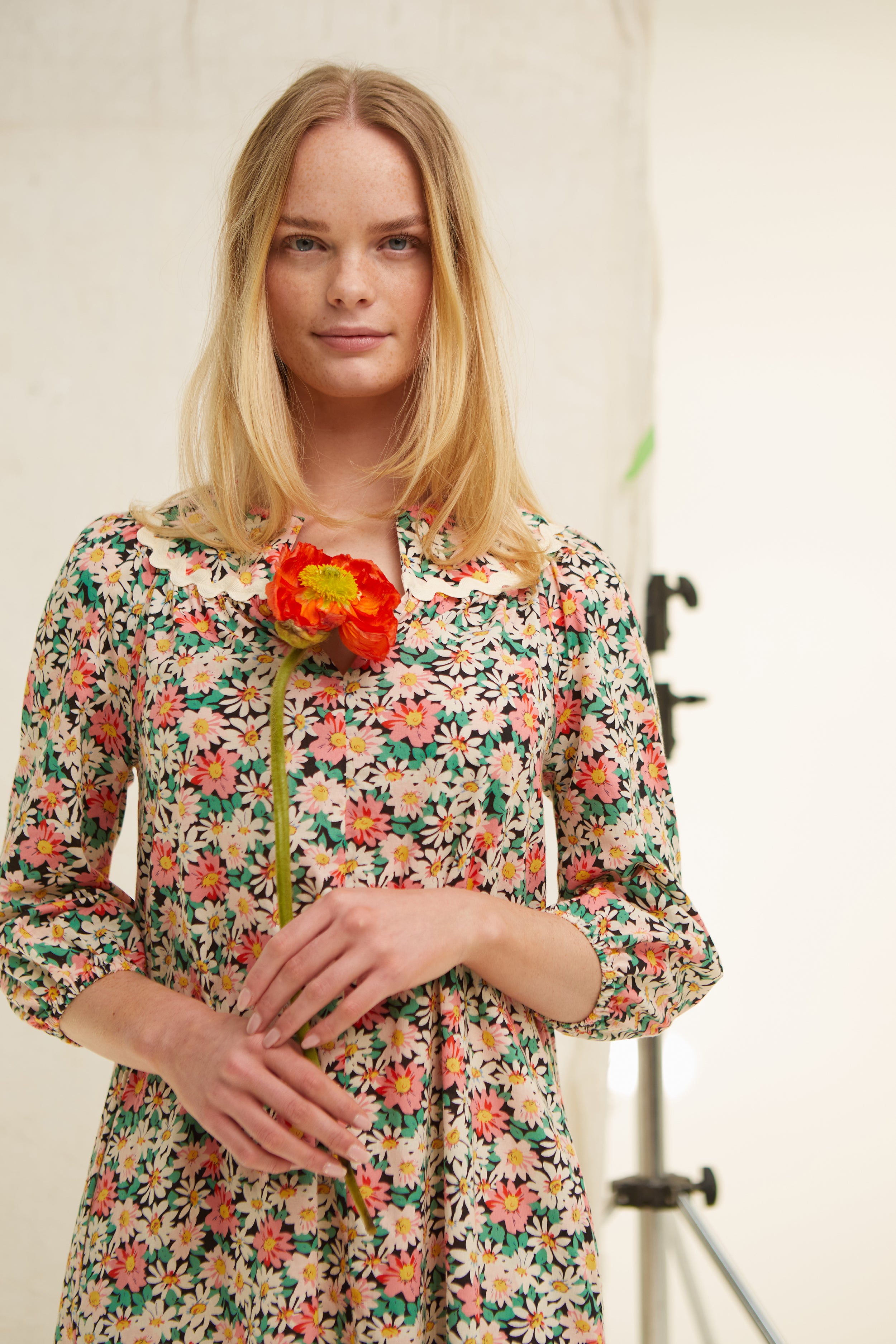 Daisy floral cotton dress. Easy cut. V neck. Yoke. Trimmed with jumbo ric rac. Deep side pockets. Easy fit. Frill at hem Low mid calf length. 100% cotton