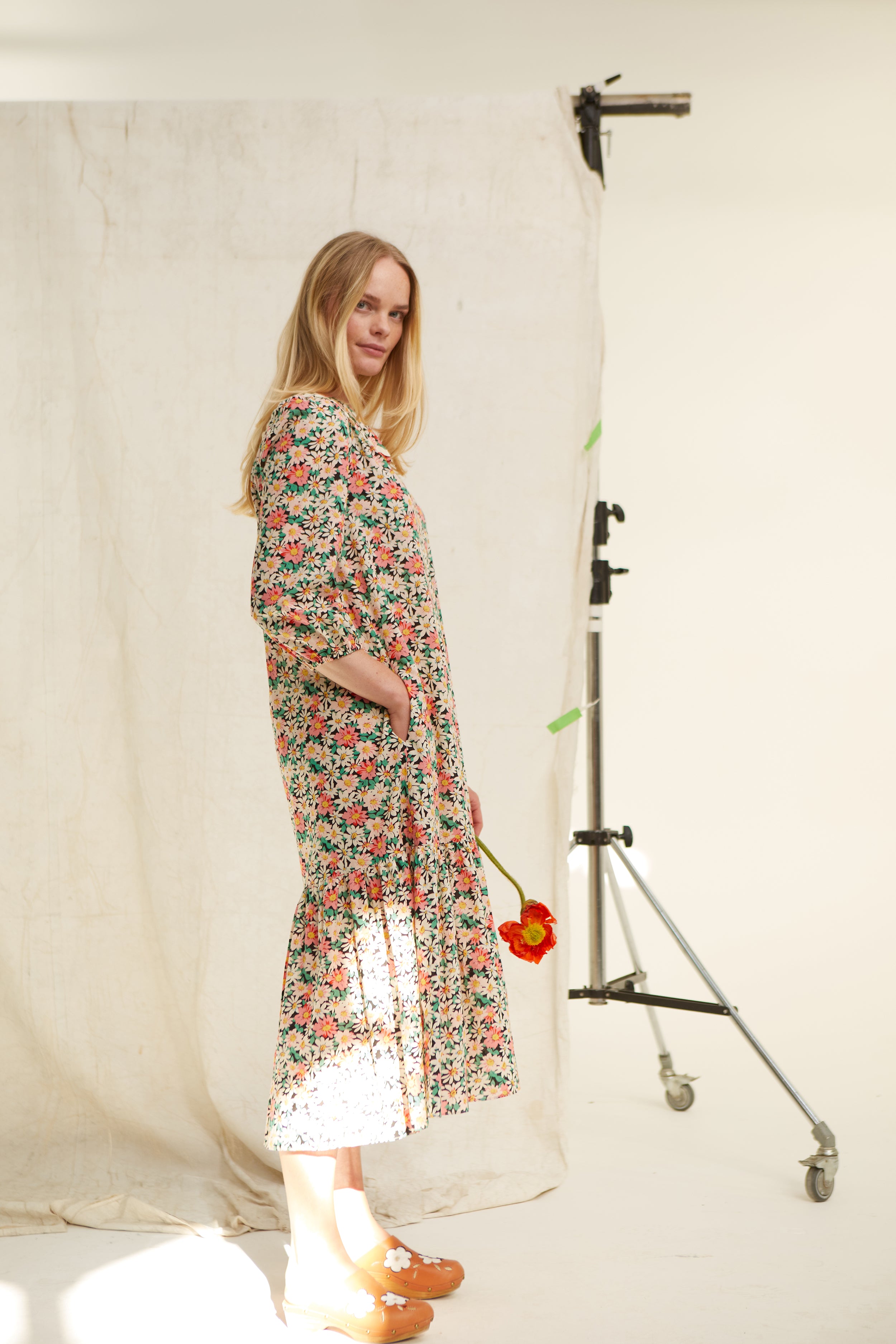 Daisy floral cotton dress. Easy cut. V neck. Yoke. Trimmed with jumbo ric rac. Deep side pockets. Easy fit. Frill at hem Low mid calf length. 100% cotton