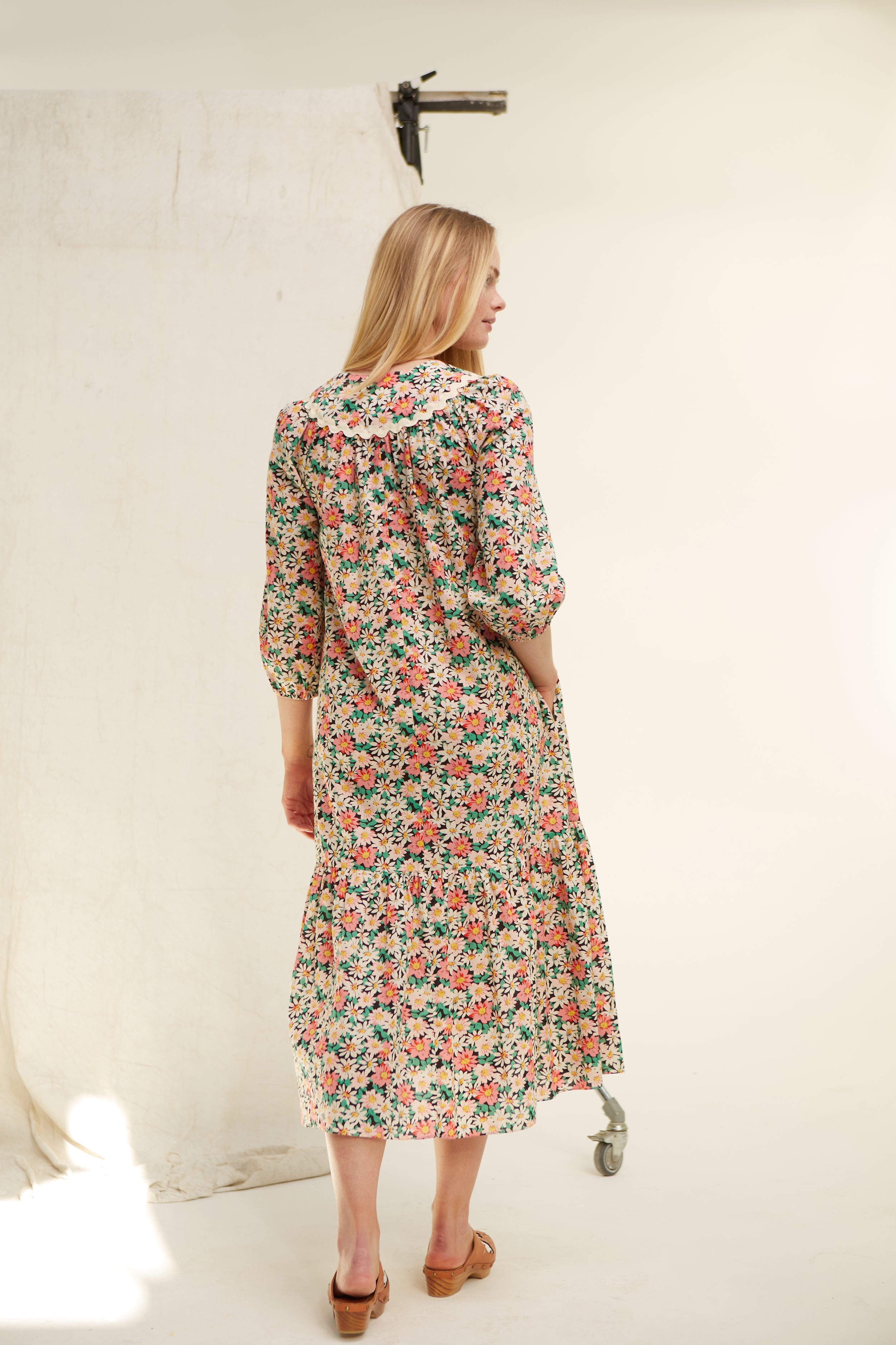 Daisy floral cotton dress. Easy cut. V neck. Yoke. Trimmed with jumbo ric rac. Deep side pockets. Easy fit. Frill at hem Low mid calf length. 100% cotton