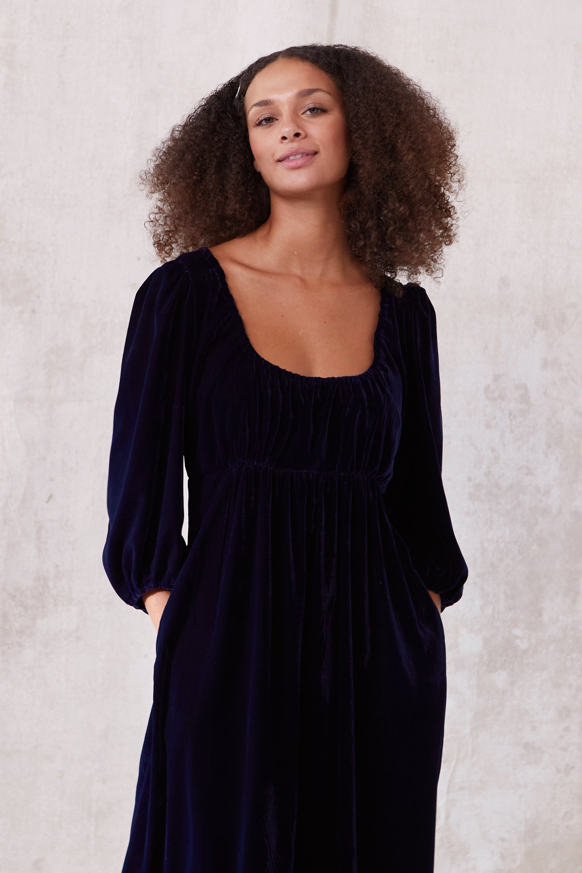 Sustainable blue velvet dress. Long sleeve, low round neck, empire line. Midi length. Made in England